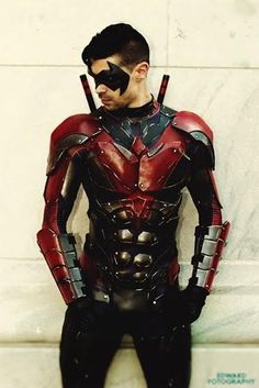 a man dressed as ant - man standing in front of a wall