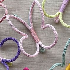 several different colored cords are arranged in the shape of letters on a tablecloth with thread