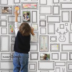 a young boy is drawing on the wall