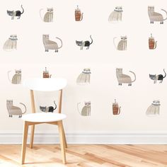 there is a wall with cats on it and one cat sitting on the chair next to the table