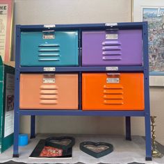 an assortment of colorful drawers sitting on top of a table next to a book shelf