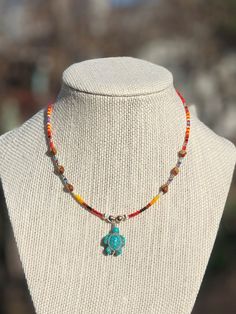 "Authentic Native American, handmade, Cedar Juniper Berry seed and Turtle pendant necklace. Cedar beads, colorful glass seed beads (size 11/0), round silver beads (6mm) and a charm are strung with jewelry wire and closed with lobster claw clasp. Navajo legend says Cedar beads, also known as \"Ghost Beads,\" will keep evil spirits and bad dreams away. For example, it is customary for Navajo mothers to place strung cedar beads on/near their traditional cradle boards used by their infants. By seaso Handmade Southwestern Beaded Necklaces For Beach, Handmade Southwestern Necklace For Beach, Southwestern Multicolor Beaded Necklaces For Beach, Southwestern Style Multicolor Beaded Necklaces For Beach, Southwestern Style Multicolor Beaded Necklace For Beach, Artisan Tiny Turquoise Beads, Southwestern Colorful Beaded Necklaces For Crafting, Bohemian Heishi Beads Turquoise Necklace Gift, Artisan Turquoise Necklace With Heishi Beads For Gift