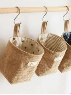 three bags hanging from a wooden rack on a wall