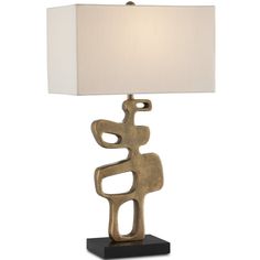 a table lamp with a white shade on it and a black base holding a gold sculpture