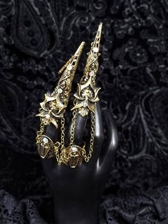 a black mannequin with gold jewelry on it's head and two hands