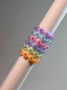 multicolored beaded bracelet sitting on top of a white pole