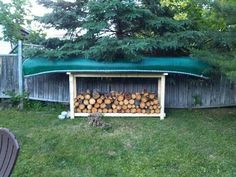 there is a firewood rack in the yard with logs stacked up on it's sides