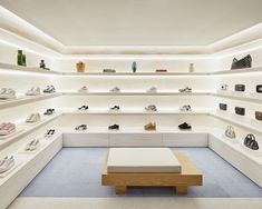 a room filled with lots of white shelves and shoes on top of each shelf in front of them