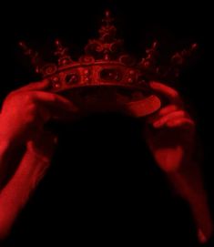 a person holding a crown in the dark