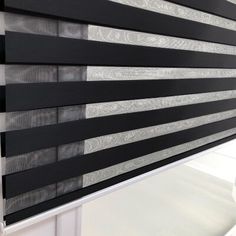 black and white striped blinds hanging on the side of a window