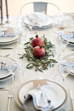 the table is set with plates, silverware and apples on it for an elegant dinner