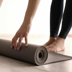 two people standing on top of a yoga mat with their hands in the middle of it