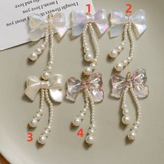 three bows and pearls are attached to the side of a white plate with numbers on it