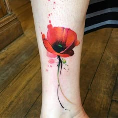 a watercolor style poppy tattoo on the ankle