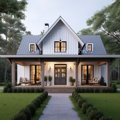 a white house with lots of windows on the front porch and covered in grass, surrounded by trees