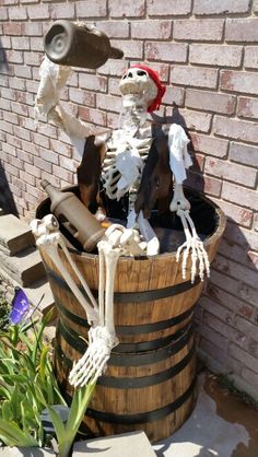 a skeleton sitting on top of a wooden barrel