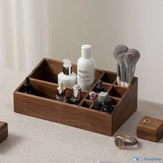 an assortment of personal care items in a wooden box on a table with white curtains