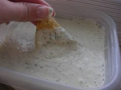 a person dipping some food into a container