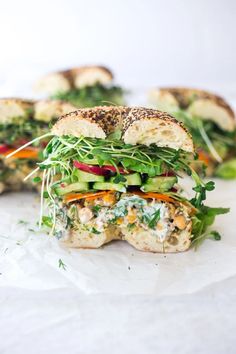 a sandwich with chicken, lettuce, carrots and other veggies