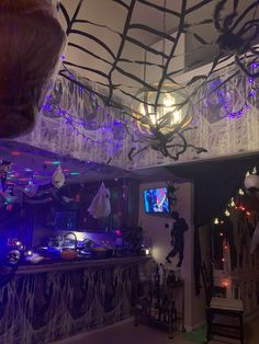 the room is decorated for halloween with lights and spider webs hanging from the ceiling