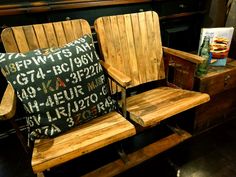 two wooden chairs sitting next to each other in front of a fireplace with signs on it