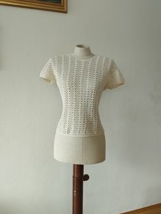 A rare 1970s white crochet shirt in beautifully designed crochet pattern. At the back of the neckline the shirt closes with a button. The crochet is 100% cotton. MEASUREMENTS (taken flat)* Armpit-to-armpit: 18'' (46 cm) Width: 15'' (38 cm) Length: 20'' (50 cm) Condition is excellent. There are no visible flaws. *Please compare measurements to a garment you currently own to ensure proper fit. visit the shop: http://www.etsy.com/shop/sherpavintage instagram | sherpa_vintage Vintage Cream Crochet Top, Vintage Cream Crochet Top With Trim, Vintage Cream Crochet Top With Crochet Trim, Vintage Open Knit Tops For Summer, Cream Crochet Lace Cotton Top, Vintage Cotton Crochet Trim Top, Fitted Crochet Top With Pointelle Knit And Short Sleeves, Fitted Cream Crochet Top With Pointelle Knit, Fitted Crew Neck Crochet Top