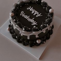 a black and white birthday cake with the words happy birthday written in frosting on it