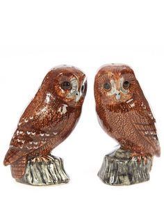 two brown owl figurines sitting on top of a tree stump with white background