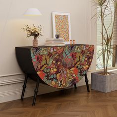 an ornately decorated console table in a living room with wood flooring and white walls