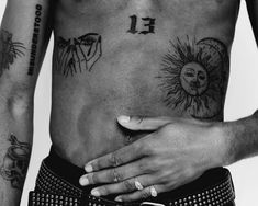 a man with tattoos on his chest and hand holding the other side of his stomach