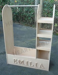 a wooden shelf with the name emelia written on it in front of a chain link fence