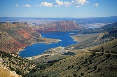 a large body of water sitting in the middle of a mountain side valley next to a lake