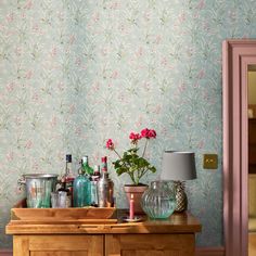 a wooden dresser topped with lots of bottles and vases