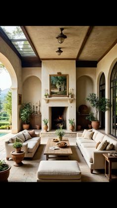 a living room filled with furniture and a fire place in the middle of an open floor plan