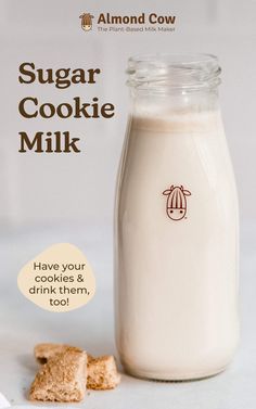 a bottle of sugar cookie milk next to some cookies on a table with an ad for almond cow