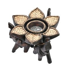 a decorative wooden object with an intricate design on it's center and two small bowls in the middle