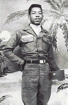 an old black and white photo of a man in uniform standing with his hands on his hips