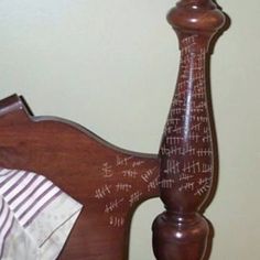 a wooden bed with writing on the headboard and foot board, in a bedroom