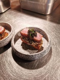 two small bowls filled with food on top of a table