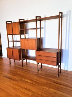 three wooden shelving units sitting next to each other on top of a hard wood floor