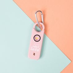 a pink keychain that has a light inside of it on top of a blue and orange background