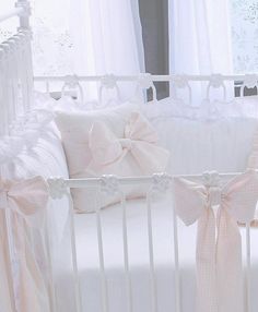 a white crib with pink bows on it