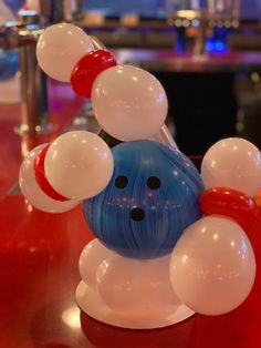 a bowling ball with red, white and blue balloons on it sitting on a table