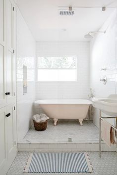 a white bathroom with a tub and sink