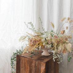 a vase filled with flowers sitting on top of a wooden box