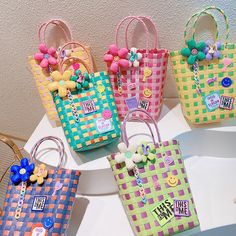 four colorful bags with flowers on them sitting on a white table next to each other