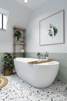 a white bath tub sitting under a window next to a plant in a bathroom with black and white flooring