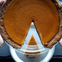 a person holding a pie in their hands with a slice missing from the pie plate