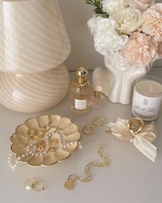 a table topped with flowers and jewelry next to a vase