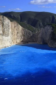 the water is blue and there are mountains in the background